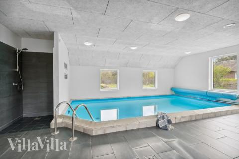 Sommarstuga 557 är inredd med en smakfull poolavdelning som har vattenrutschbana, ett stort inbyggt spapad och bastu