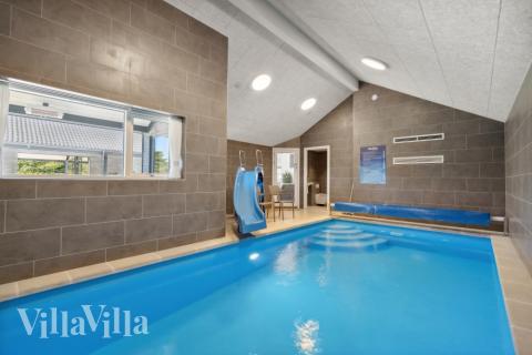 Sommarstuga 596 är inredd med en smakfull poolavdelning som har vattenrutschbana, ett stort inbyggt spapad och bastu