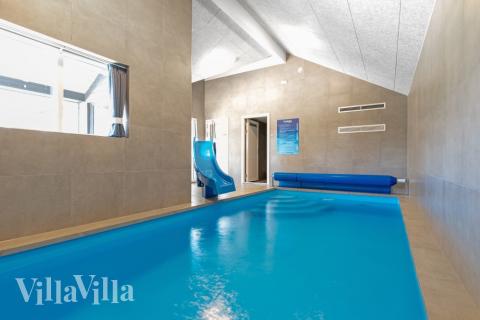 Sommarstuga 597 är inredd med en smakfull poolavdelning som har vattenrutschbana, ett stort inbyggt spapad och bastu