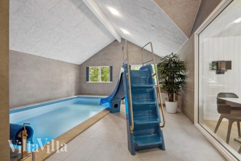 Sommarstuga 750 är inredd med en smakfull poolavdelning som har vattenrutschbana, ett stort inbyggt spapad och bastu