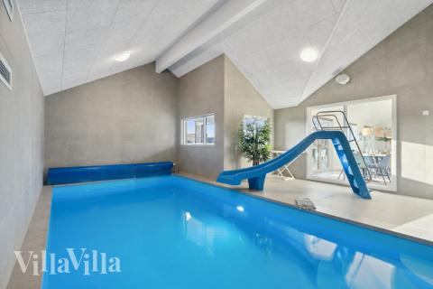 Sommarstuga 605 är inredd med en smakfull poolavdelning som har vattenrutschbana, ett stort inbyggt spapad och bastu