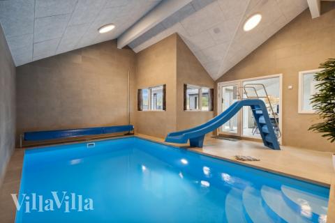 Sommarstuga 610 är inredd med en smakfull poolavdelning som har vattenrutschbana, ett stort inbyggt spapad och bastu