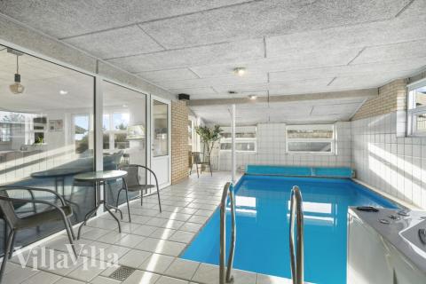 Sommarstuga 613 är inredd med en smakfull poolavdelning som har vattenrutschbana, ett stort inbyggt spapad och bastu