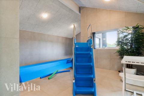 Sommarstuga 634 är inredd med en smakfull poolavdelning som har vattenrutschbana, ett stort inbyggt spapad och bastu