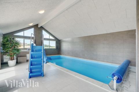 Sommarstuga 830 är inredd med en smakfull poolavdelning som har vattenrutschbana, ett stort inbyggt spapad och bastu