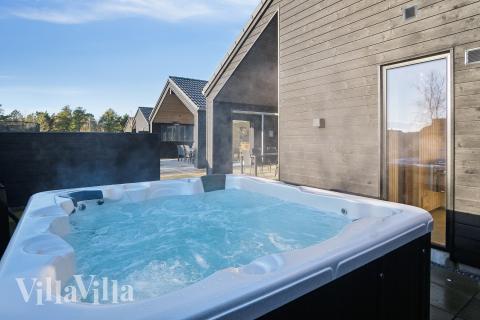 Njut av spabadets värme i lyxstuga nr 597 i Sydjylland