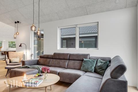 I soffhörnan i lyxstuga 692 i Nordjylland kan ni spela brädspel eller titta på film tillsammans.