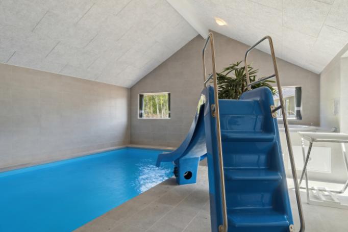 Sommarstuga 803 är inredd med en smakfull poolavdelning som har vattenrutschbana, ett stort inbyggt spapad och bastu