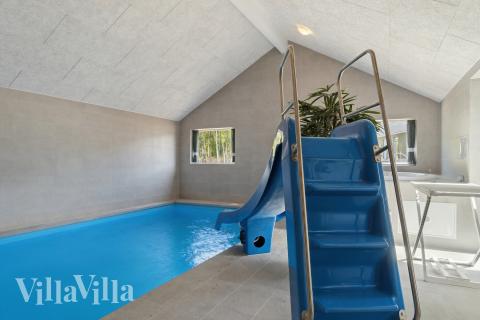 Sommarstuga 803 är inredd med en smakfull poolavdelning som har vattenrutschbana, ett stort inbyggt spapad och bastu