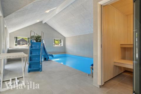 Sommarstuga 809 är inredd med en smakfull poolavdelning som har vattenrutschbana, ett stort inbyggt spapad och bastu