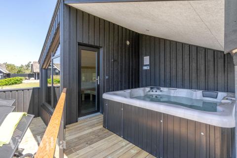 Njut av spabadets värme i lyxstuga nr 909 i Nordjylland