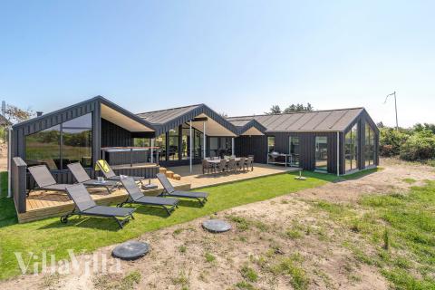 Den praktfulla poolstugan nr 909 med plats för 12 personer ligger i Nordjylland