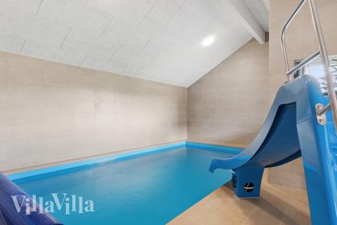 Sommarstuga 695 är inredd med en smakfull poolavdelning som har vattenrutschbana, ett stort inbyggt spapad och bastu