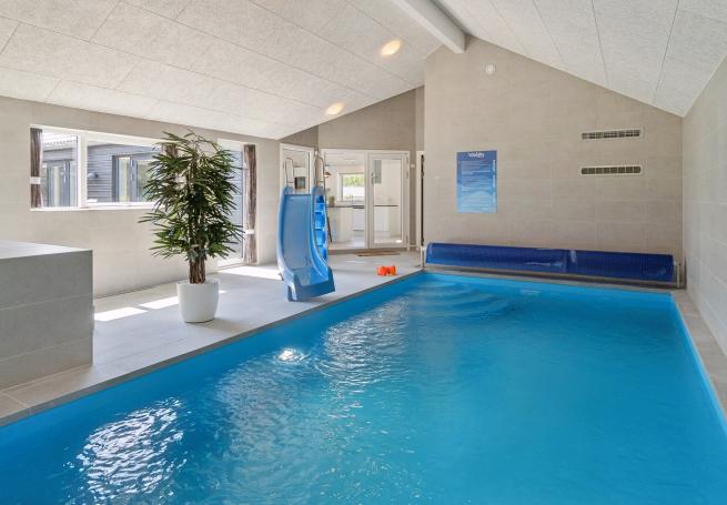 Sommarstuga 815 är inredd med en smakfull poolavdelning som har vattenrutschbana, ett stort inbyggt spapad och bastu