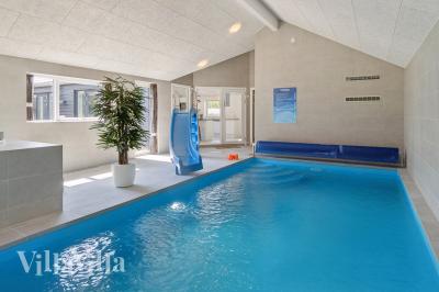 Sommarstuga 815 är inredd med en smakfull poolavdelning som har vattenrutschbana, ett stort inbyggt spapad och bastu