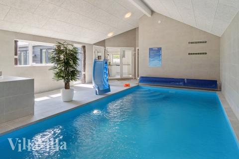 Sommarstuga 815 är inredd med en smakfull poolavdelning som har vattenrutschbana, ett stort inbyggt spapad och bastu