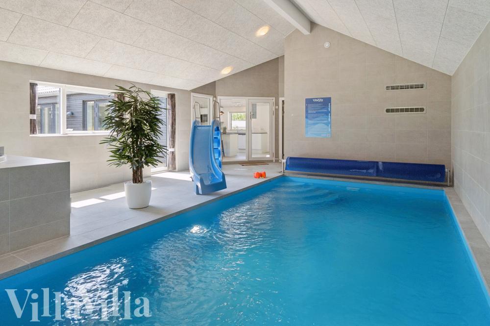 Sommarstuga 815 är inredd med en smakfull poolavdelning som har vattenrutschbana, ett stort inbyggt spapad och bastu
