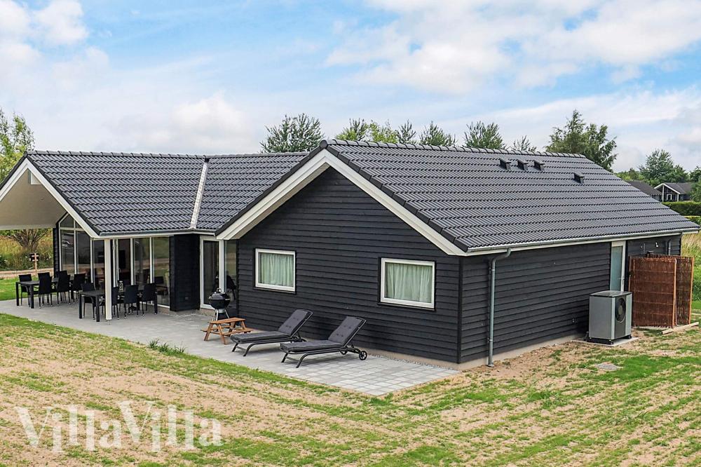 Den praktfulla poolstugan nr 670 med plats för 12 personer ligger i Lolland/Falster/Møn