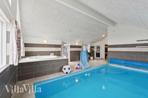 Sommarstuga 404 är inredd med en smakfull poolavdelning som har vattenrutschbana, ett stort inbyggt spapad och bastu