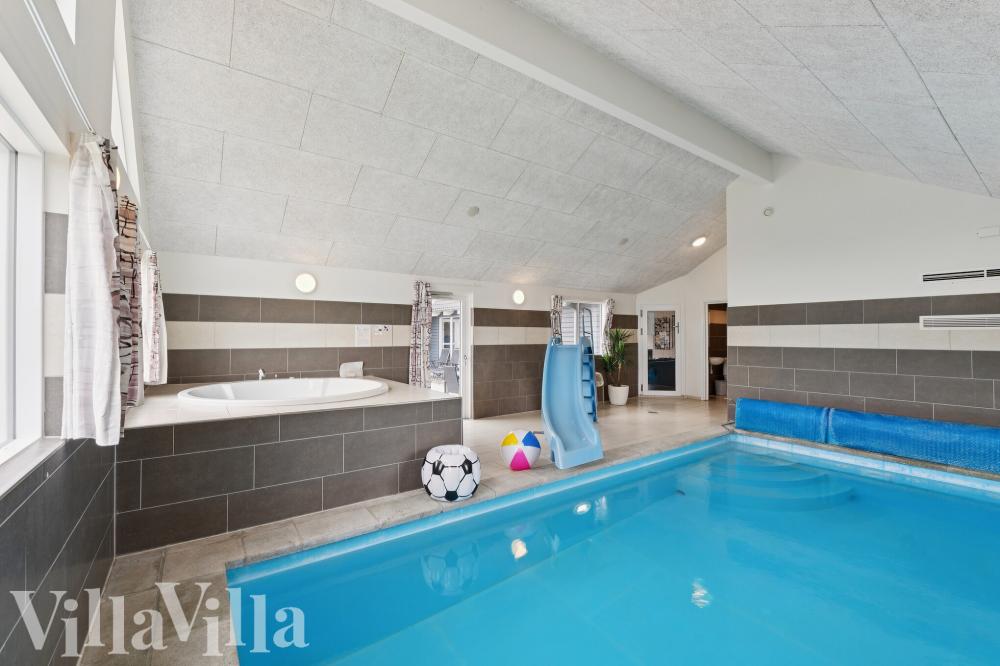 Sommarstuga 404 är inredd med en smakfull poolavdelning som har vattenrutschbana, ett stort inbyggt spapad och bastu