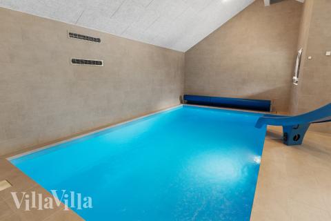 Sommarstuga 697 är inredd med en smakfull poolavdelning som har vattenrutschbana, ett stort inbyggt spapad och bastu