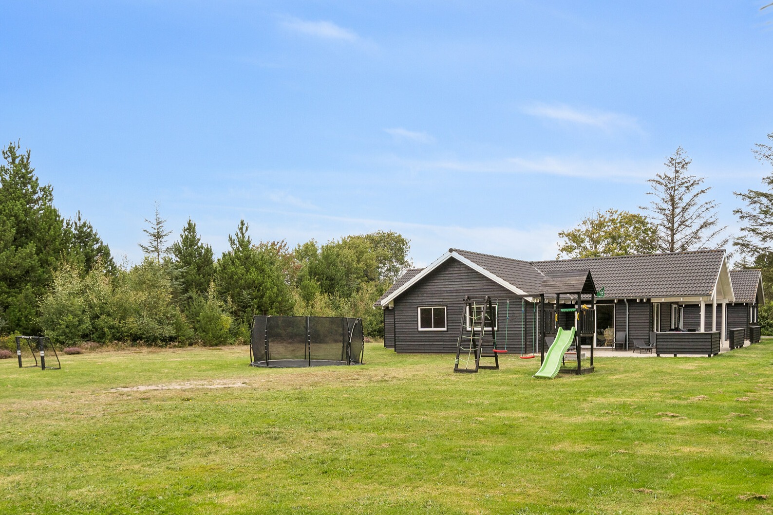 Till den trevliga sommarstugan nr 387 i Vestjylland erbjuds en mängd utomhusaktiviteter, t.ex. lektorn och gungor