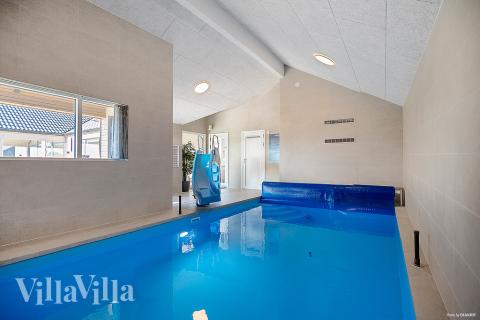 Sommarstuga 913 är inredd med en smakfull poolavdelning som har vattenrutschbana, ett stort inbyggt spapad och bastu