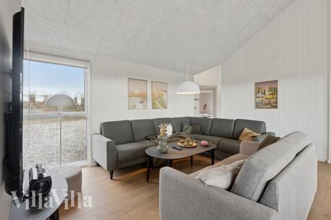 I soffhörnan i lyxstuga 902 i Nordjylland kan ni spela brädspel eller titta på film tillsammans.