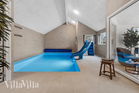 Sommarstuga 905 är inredd med en smakfull poolavdelning som har vattenrutschbana, ett stort inbyggt spapad och bastu