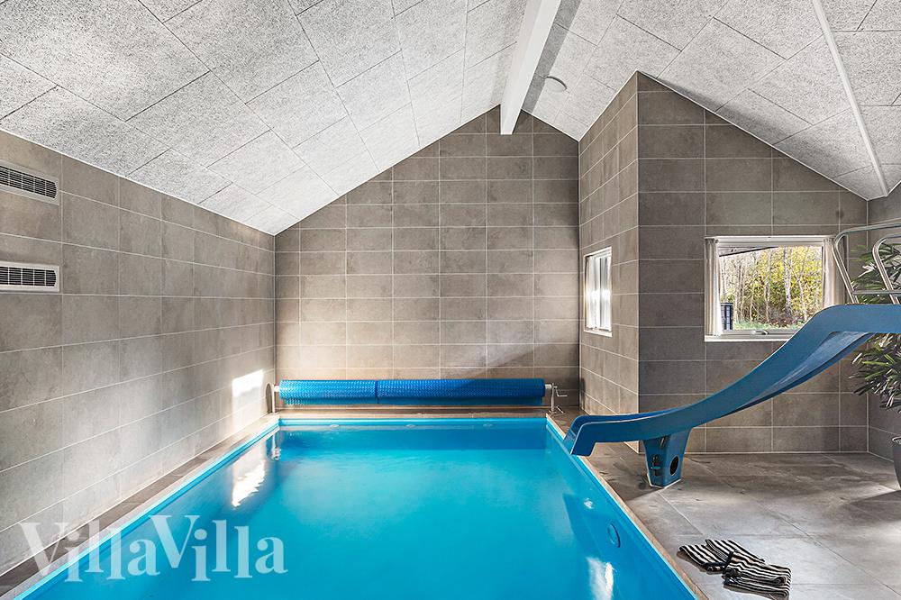 Sommarstuga 911 är inredd med en smakfull poolavdelning som har vattenrutschbana, ett stort inbyggt spapad och bastu