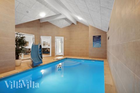 Sommarstuga 933 är inredd med en smakfull poolavdelning som har vattenrutschbana, ett stort inbyggt spapad och bastu