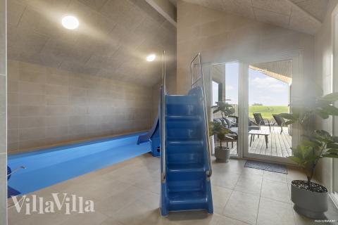 Sommarstuga 906 är inredd med en smakfull poolavdelning som har vattenrutschbana, ett stort inbyggt spapad och bastu