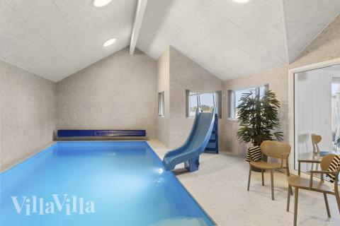 Sommarstuga 910 är inredd med en smakfull poolavdelning som har vattenrutschbana, ett stort inbyggt spapad och bastu