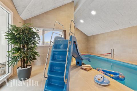 Sommarstuga 918 är inredd med en smakfull poolavdelning som har vattenrutschbana, ett stort inbyggt spapad och bastu