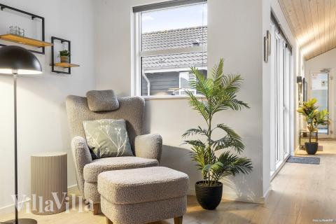 I soffhörnan i lyxstuga 196 i Nordjylland kan ni spela brädspel eller titta på film tillsammans.