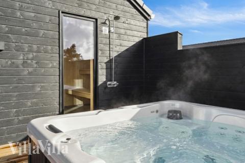 Njut av spabadets värme i lyxstuga nr 599 i Sydjylland