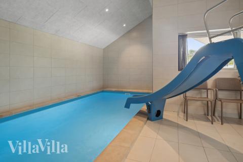 Sommarstuga 915 är inredd med en smakfull poolavdelning som har vattenrutschbana, ett stort inbyggt spapad och bastu