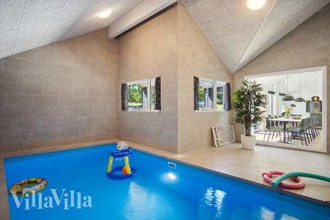 Sommarstuga 904 är inredd med en smakfull poolavdelning som har vattenrutschbana, ett stort inbyggt spapad och bastu