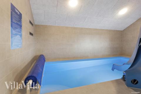 Sommarstuga 916 är inredd med en smakfull poolavdelning som har vattenrutschbana, ett stort inbyggt spapad och bastu