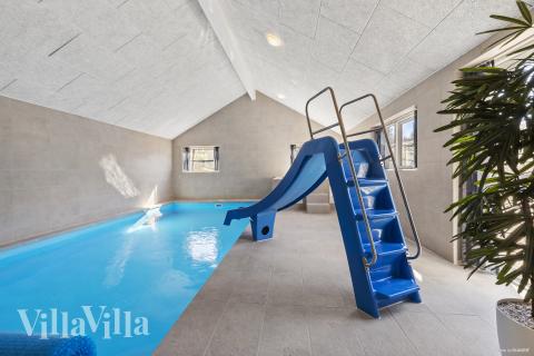 Sommarstuga 822 är inredd med en smakfull poolavdelning som har vattenrutschbana, ett stort inbyggt spapad och bastu