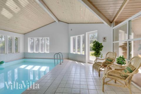 Sommarstuga 963 är inredd med en smakfull poolavdelning som har vattenrutschbana, ett stort inbyggt spapad och bastu