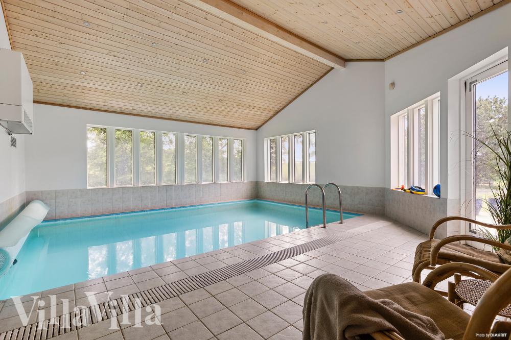 Sommarstuga 963 är inredd med en smakfull poolavdelning som har vattenrutschbana, ett stort inbyggt spapad och bastu