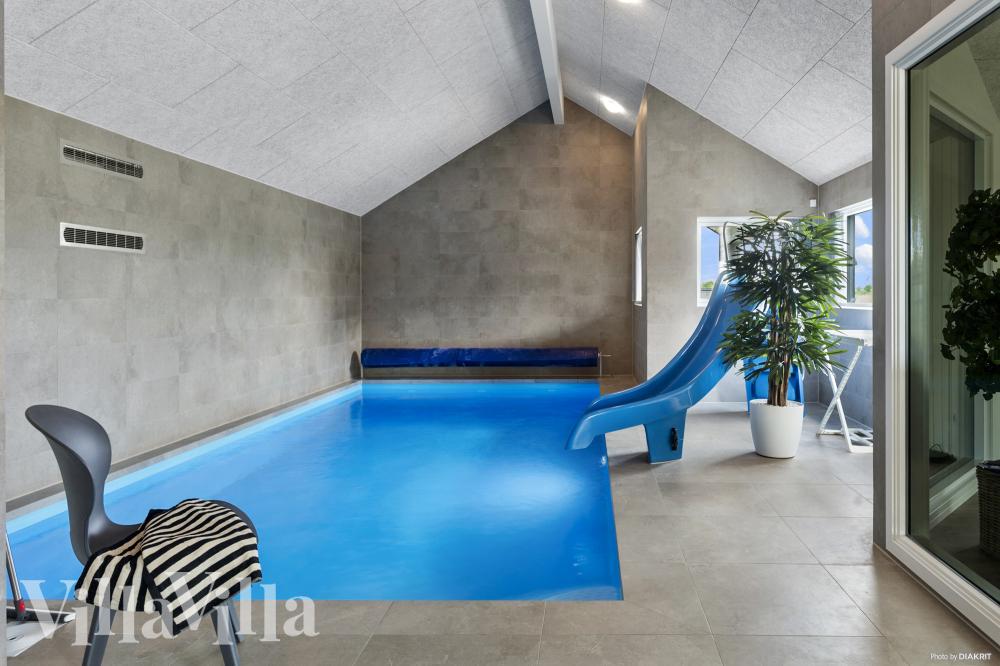 Sommarstuga 923 är inredd med en smakfull poolavdelning som har vattenrutschbana, ett stort inbyggt spapad och bastu