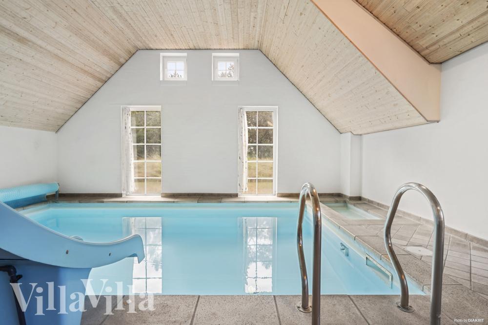 Sommarstuga 989 är inredd med en smakfull poolavdelning som har vattenrutschbana, ett stort inbyggt spapad och bastu