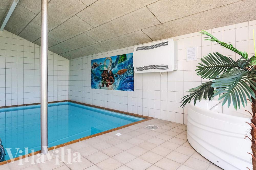 Sommarstuga 1003 är inredd med en smakfull poolavdelning som har vattenrutschbana, ett stort inbyggt spapad och bastu