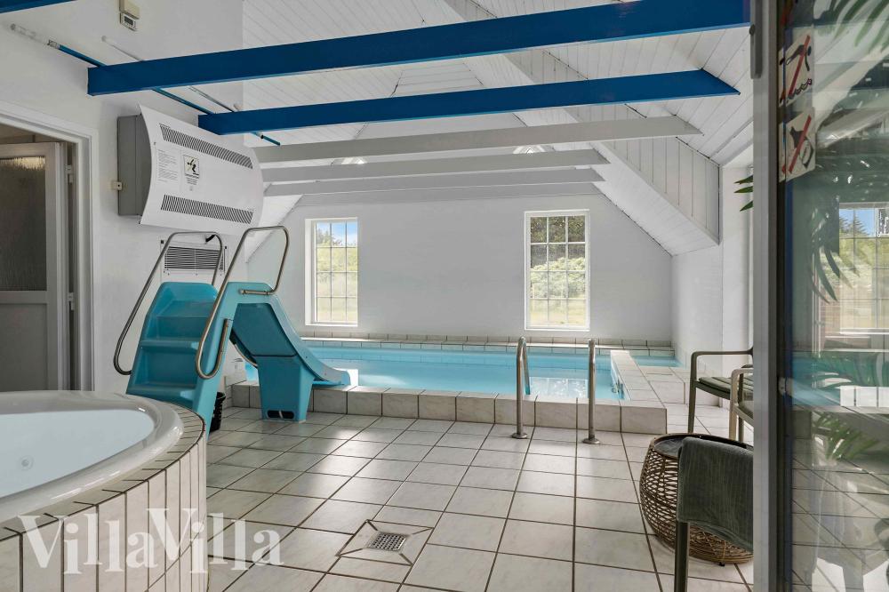 Sommarstuga 1005 är inredd med en smakfull poolavdelning som har vattenrutschbana, ett stort inbyggt spapad och bastu